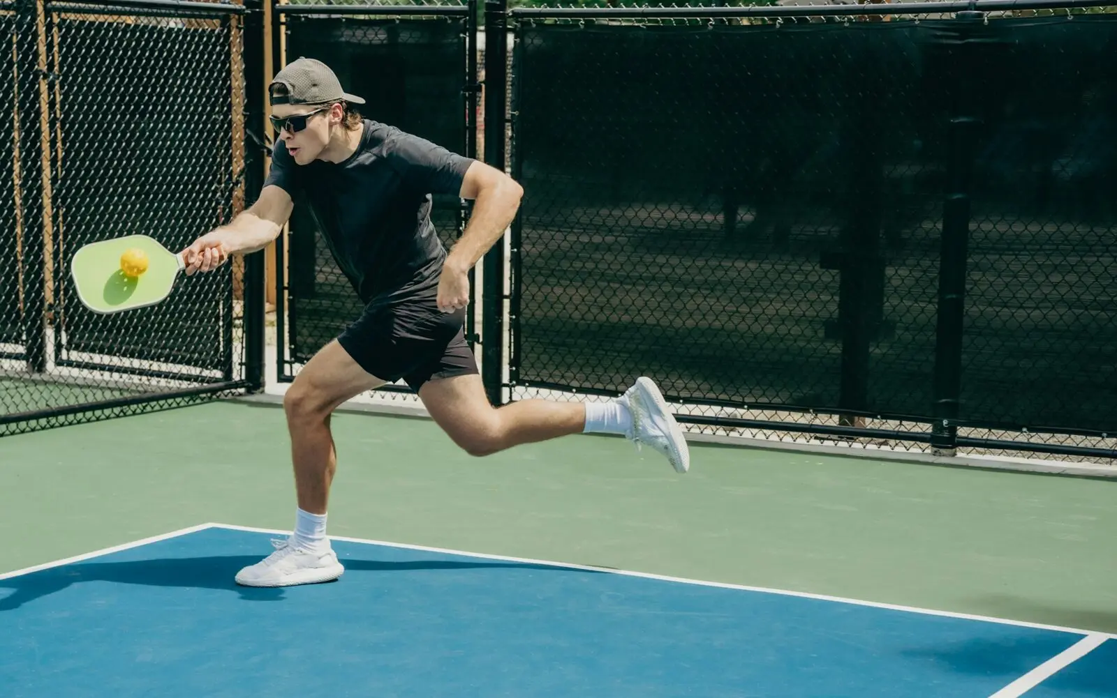 Pickleball player returning a shot on an outdoor court