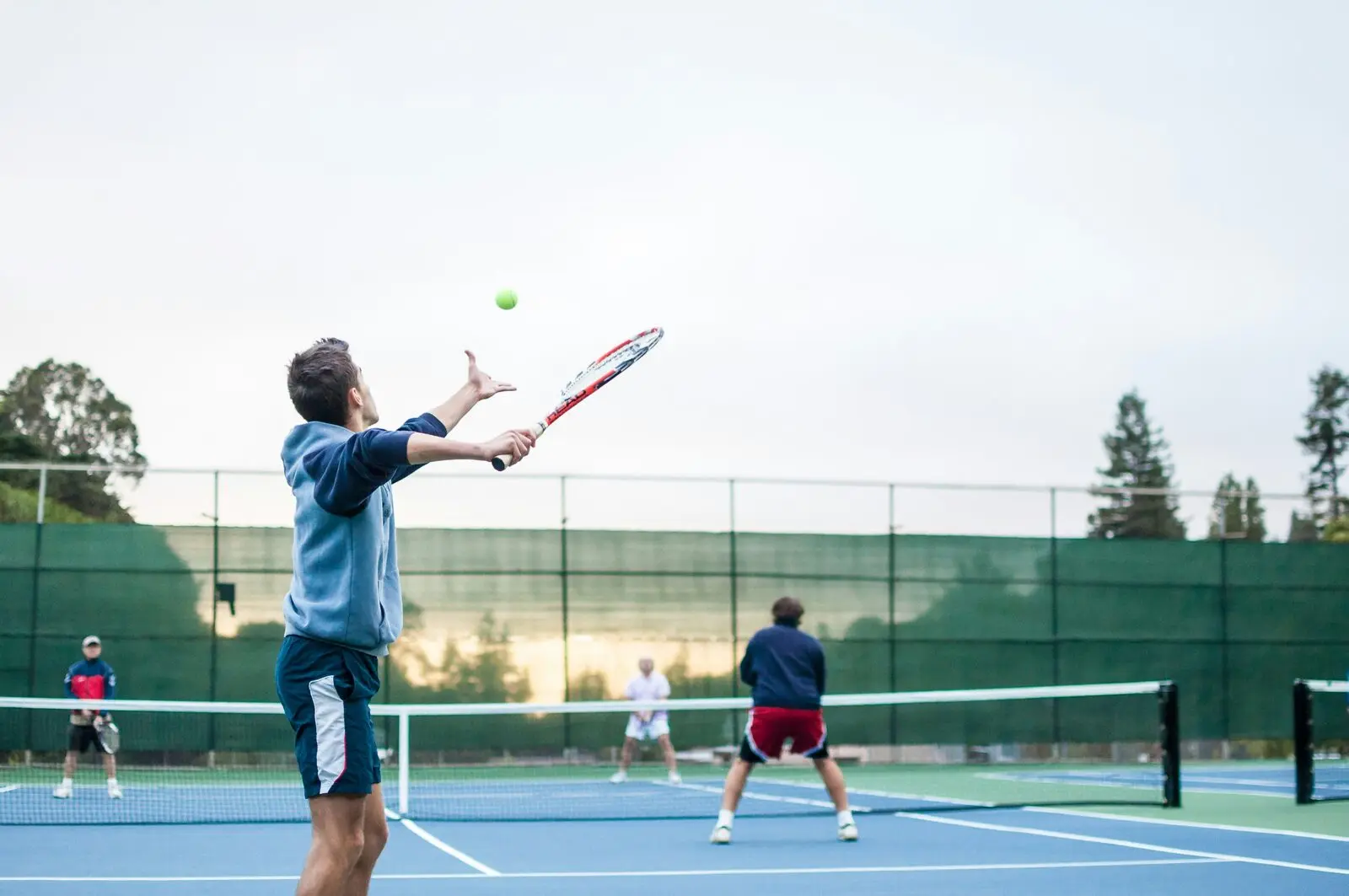 Tennis player serving on an outdoor court