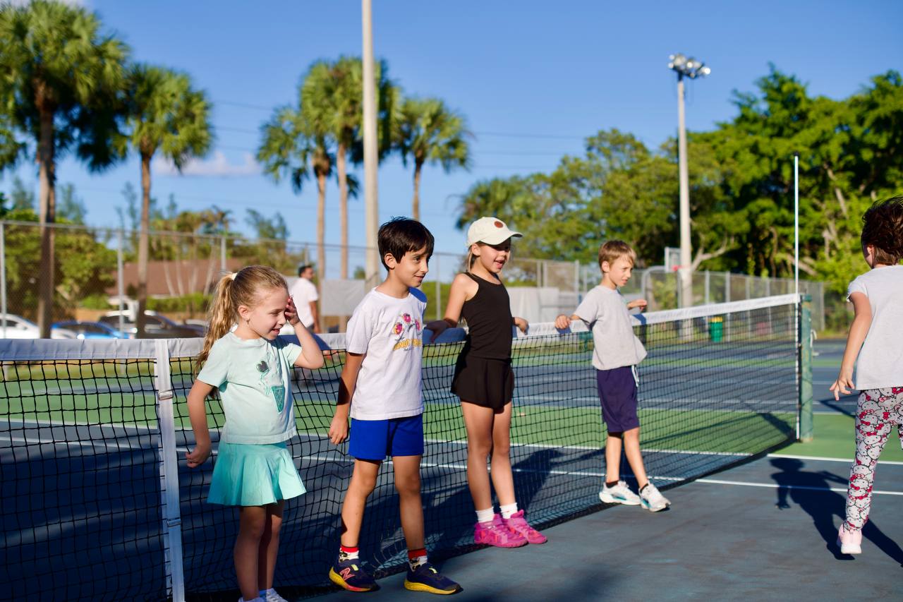 Young players waiting their turn at the net on a sunny afternoon