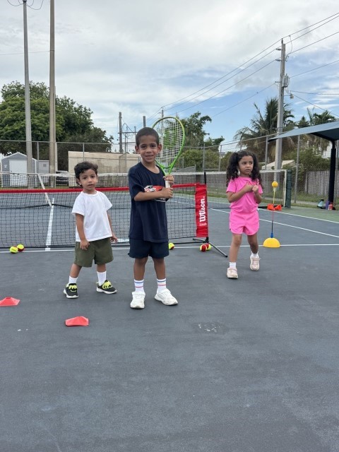 Small children with rackets at a mini-tennis net